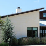 Austin limestone cladding panels are smooth white exterior stone panels on the exterior of a contemporary home